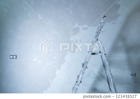 A ladder is positioned against a wall as adhesive is applied to repair surface damage. 121438327