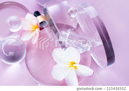 Display includes serum with aloe and centella, surrounded by glass elements and flower petals. Flat lay. Display includes serum with aloe and centella, surrounded by glass elements and flower petals. Flat lay. 121438332