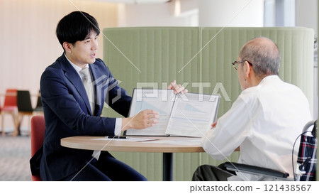 A businessman selling to elderly people 121438567