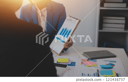 Meeting with business partners to discuss financial advisors to analyze market growth charts in business reports and plan investment strategies. 121438737