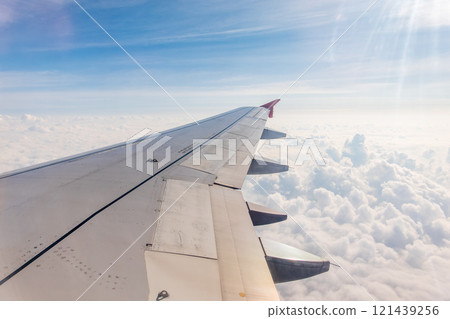 View from the airplane window at a beautiful cloudy sky and the airplane wing View from the airplane window at a beautiful cloudy sky and the airplane wing 121439256