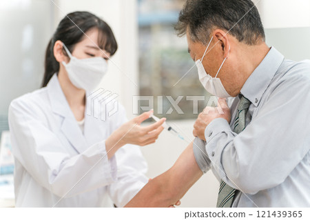給予疫苗/注射的女醫生和老年男性患者 121439365