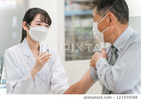 給予疫苗/注射的女醫生和老年男性患者 121439366
