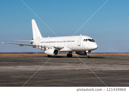 White passenger airplane taxiing at the airport apron 121439968