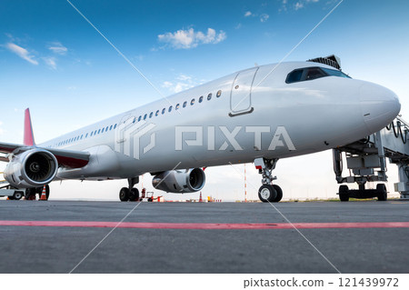 A white passenger jet plane at the boarding bridge 121439972