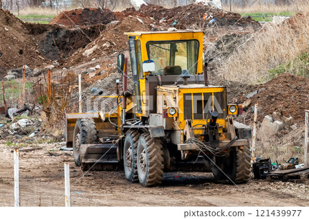 Yellow grader in a landfill Yellow grader in a landfill 121439977