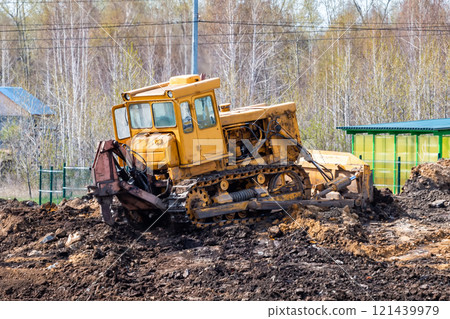 Yellow bulldozer leveling the ground at a construction site Yellow bulldozer leveling the ground at a construction site 121439979