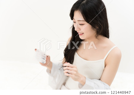 Young woman holding a supplement case 121440947
