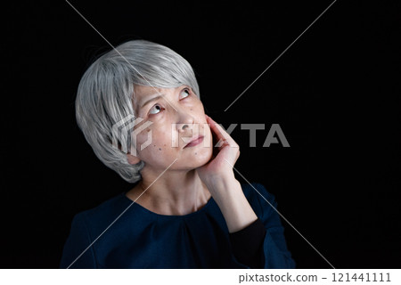 一位老婦人托著下巴，憂心忡忡 121441111