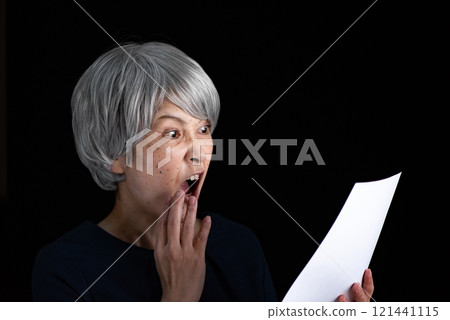 驚訝地看著文件的高級女性 121441115
