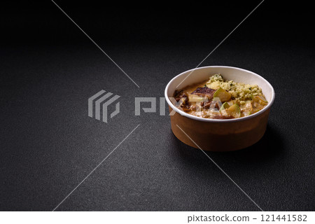 Bowl of food with beef, bulgur, tomatoes, zucchini and sauce 121441582