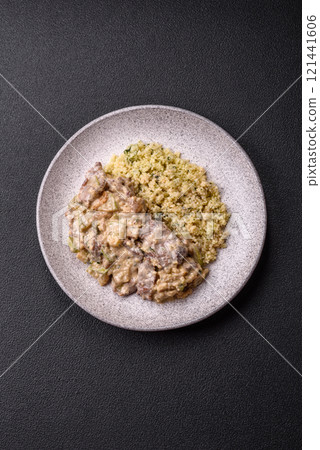 Bowl of food with beef, bulgur, tomatoes, zucchini and sauce 121441606