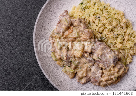 Bowl of food with beef, bulgur, tomatoes, zucchini and sauce 121441608