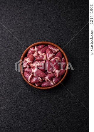 Raw chicken hearts with salt, spices and herbs 121441908