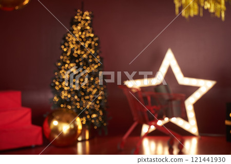A blurry image in the New Year's decoration, the decor is done in red tones. Christmas tree in the interior in red and gold tones with space for copying. High quality photo A blurry image in the New Year's decoration, the decor is done in red tones. Christmas tree in the interior in red and gold tones with space for copying. High quality photo 121441930