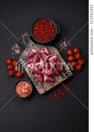 Raw chicken hearts with salt, spices and herbs 121441931