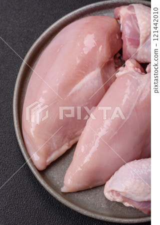 Pieces of raw chicken or turkey fillet with salt, spices and herbs 121442010