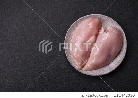 Pieces of raw chicken or turkey fillet with salt, spices and herbs 121442030