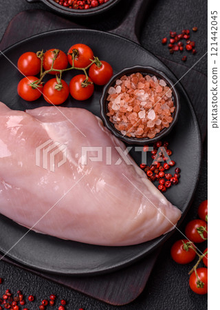 Pieces of raw chicken or turkey fillet with salt, spices and herbs 121442045