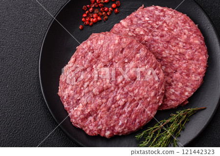 Fresh raw ground beef burger patty with salt and spices 121442323