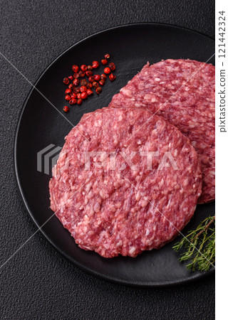 Fresh raw ground beef burger patty with salt and spices 121442324