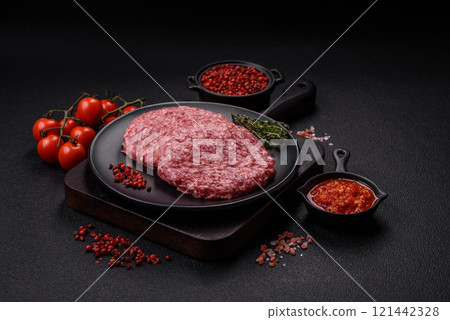 Fresh raw ground beef burger patty with salt and spices 121442328