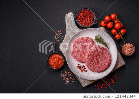 Fresh raw ground beef burger patty with salt and spices 121442344