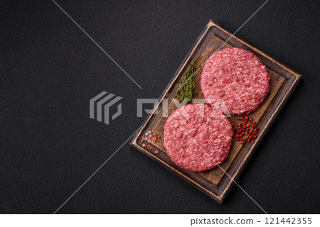 Fresh raw ground beef burger patty with salt and spices 121442355