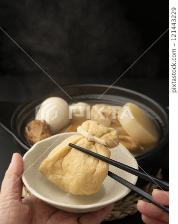 用筷子夾起關東煮 用筷子夾起關東煮 121443229