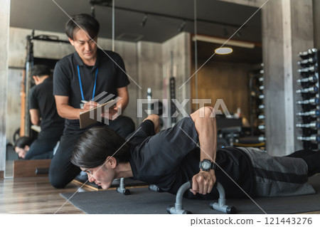 年輕的亞洲男子在體育館接受個人訓練 121443276