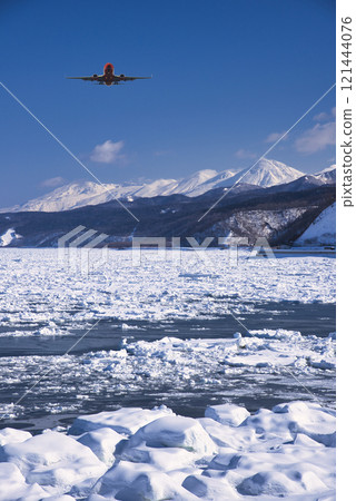 A seasonal sight in winter: an airplane flying over the drift ice of the Sea of Okhotsk 121444076