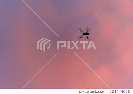 A drone flying in the sunset sky 121444638