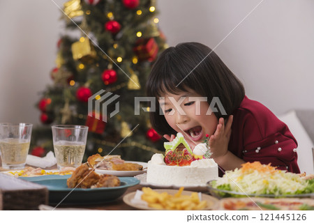 Girl enjoying Christmas cake 121445126