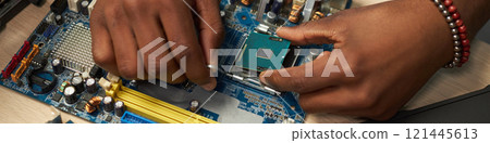 Man Repairing Computer Motherboard In Workshop 121445613