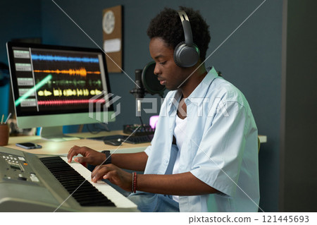 Musician In Headphones Playing Synthesizer Musician In Headphones Playing Synthesizer 121445693