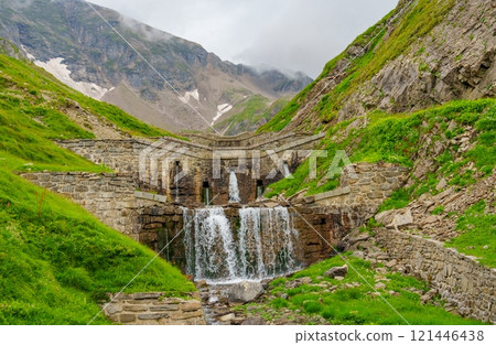 Amazing view of a beautiful waterfall cascading down a rocky mountainside. Amazing view of a beautiful waterfall cascading down a rocky mountainside. 121446438
