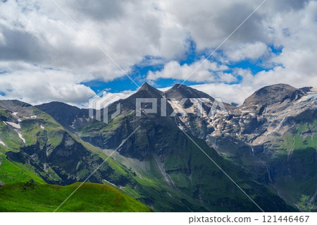 Majestic Alpine Mountains in Kaprun, Austria with Green Hills and Snow-Capped Peaks Majestic Alpine Mountains in Kaprun, Austria with Green Hills and Snow-Capped Peaks 121446467