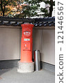An old, red cylindrical mailbox 121446567