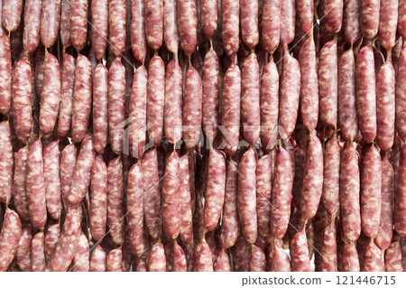 Close-up of ungrilled Taiwanese sausage bunches hanging on wooden sticks. This is one of the street snacks popular among tourists in Taiwan. 121446715