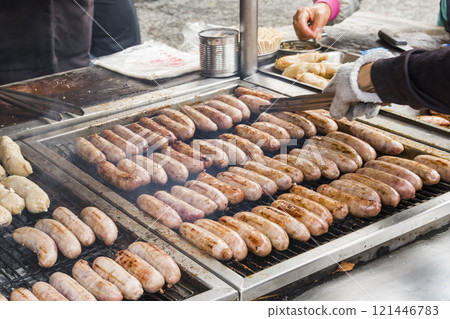 Close-up of the vendors grilling Taiwanese sausage and sticky rice (glutinous rice) sausage in the night market in Taiwan. This is one of the street snacks popular among tourists in Taiwan. Close-up of the vendors grilling Taiwanese sausage and sticky rice (glutinous rice) sausage in the night market in Taiwan. This is one of the street snacks popular among tourists in Taiwan. 121446783
