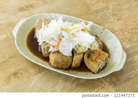 Close-up of delicious stinky tofu on the table. It is a common street snack in night markets or roadside stalls in Taiwan and is very popular among tourists. Close-up of delicious stinky tofu on the table. It is a common street snack in night markets or roadside stalls in Taiwan and is very popular among tourists. 121447373