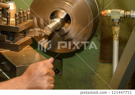 The machine operator working with lathe machine. 121447751