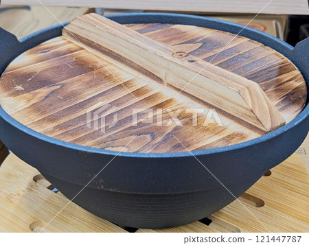 An iron pot and wooden lid for making hot pot dishes 121447787