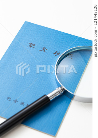 白色背景中的退休金筆記本和放大鏡 白色背景中的退休金筆記本和放大鏡 121448126