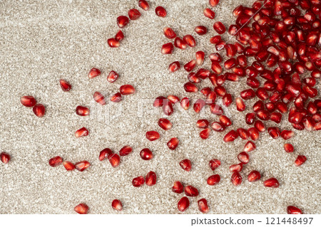 Scattered pomegranate seeds on a gray stone background Scattered pomegranate seeds on a gray stone background 121448497