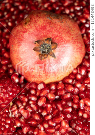 A whole pomegranate and pomegranate grains close-up. 121448498