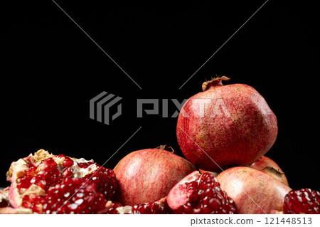 Ripe pomegranates, peeled and whole, place for text 121448513