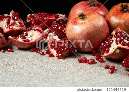 Ripe pomegranates, peeled and whole, place for text 121448519