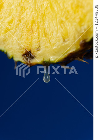 A drop of pineapple juice dripping from half a fresh pineapple. A drop of pineapple juice dripping from half a fresh pineapple. 121448539