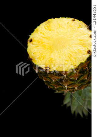 Slice of fresh pineapple fruit in the air flying on black background 121448553